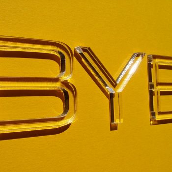 Buchstaben aus durchsichtigem Plexiglas in 3mm Materialstärke auf gelbem Hintergrund